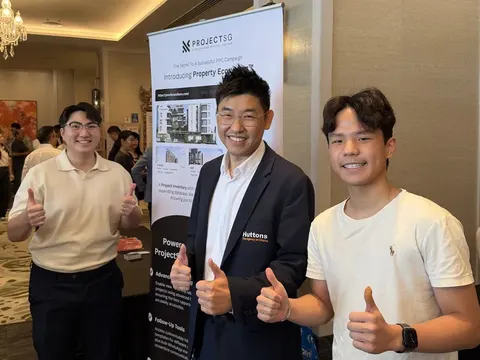 Three men giving a thumbs up beside a ProjectSG roll-up banner introducing the Property Ecosystem, at a hotel event